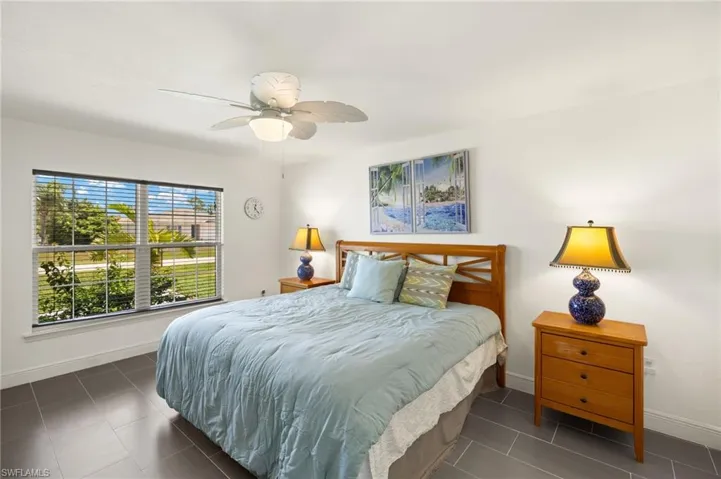Bedroom with baseboards, tile patterned floors, and a ceiling fan