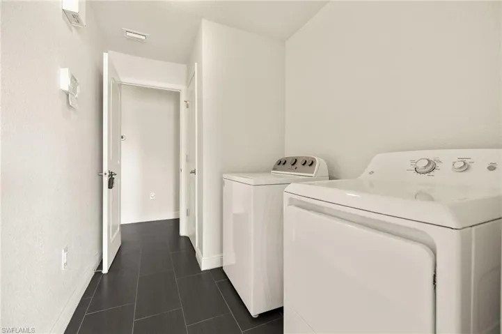 Laundry room featuring washing machine and dryer and baseboards