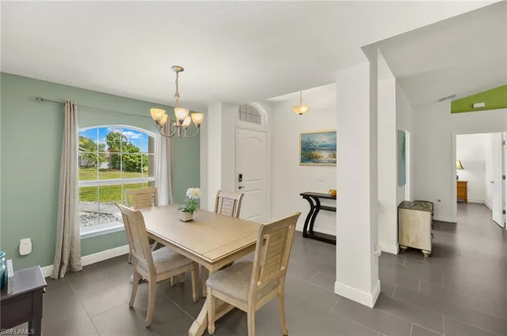 Dining space with a chandelier, baseboards, and vaulted ceiling