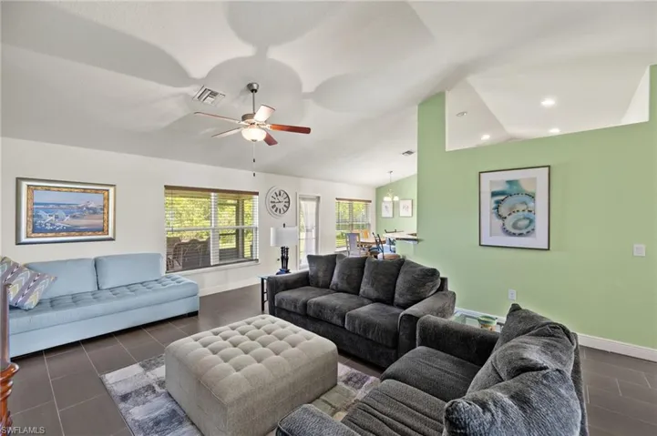 Living area featuring baseboards, a ceiling fan, recessed lighting, and vaulted ceiling