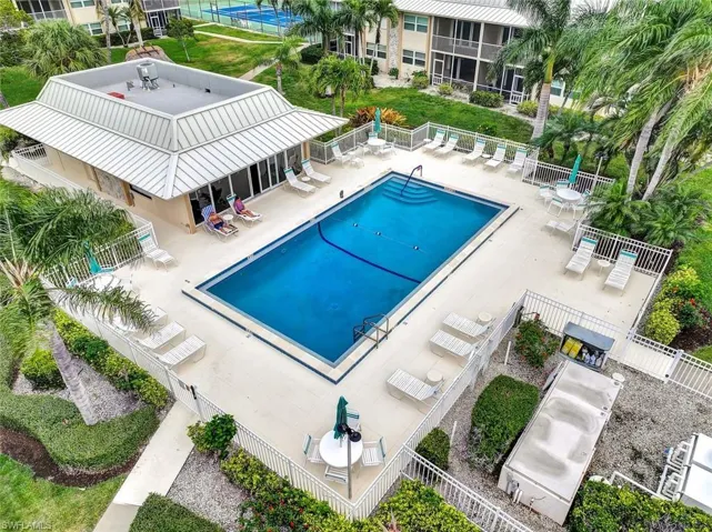 Community pool with a patio area and fence