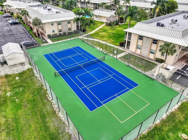 View of sport court featuring a residential view and fence