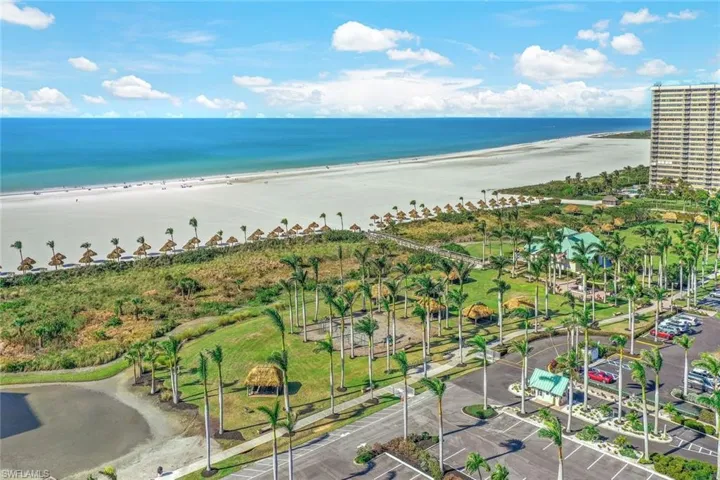 Birds eye view of property with a water view and a view of the beach