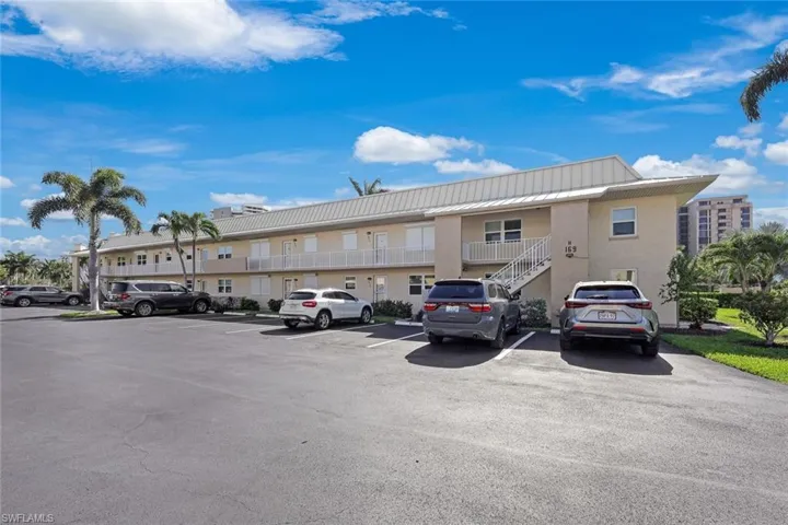 View of building exterior with uncovered parking