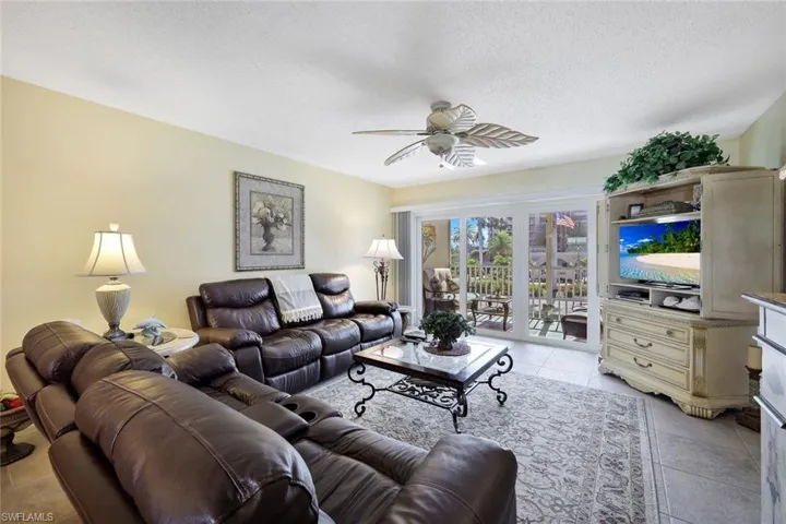 Living room with light tile patterned floors, a textured ceiling, and a ceiling fan