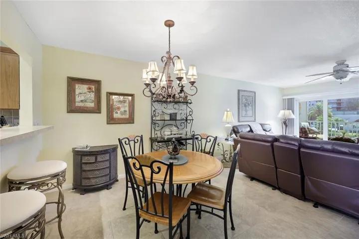 Dining space with baseboards and ceiling fan with notable chandelier