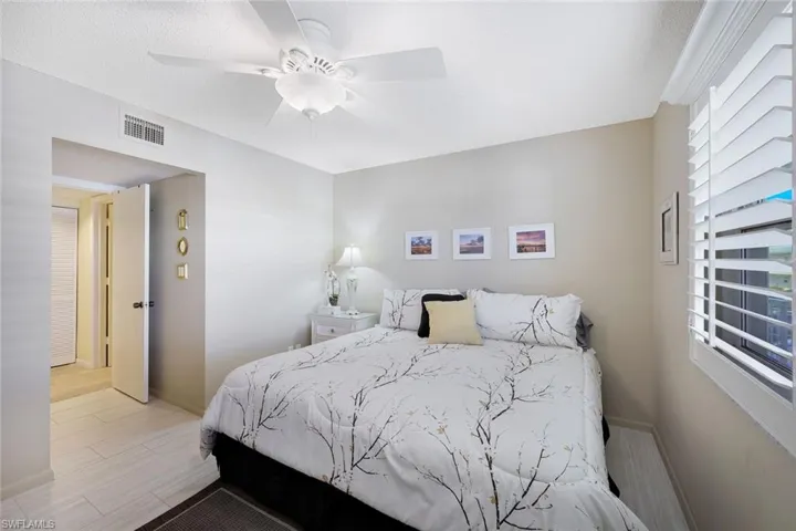 Bedroom featuring visible vents, ceiling fan, light wood-style floors, and baseboards