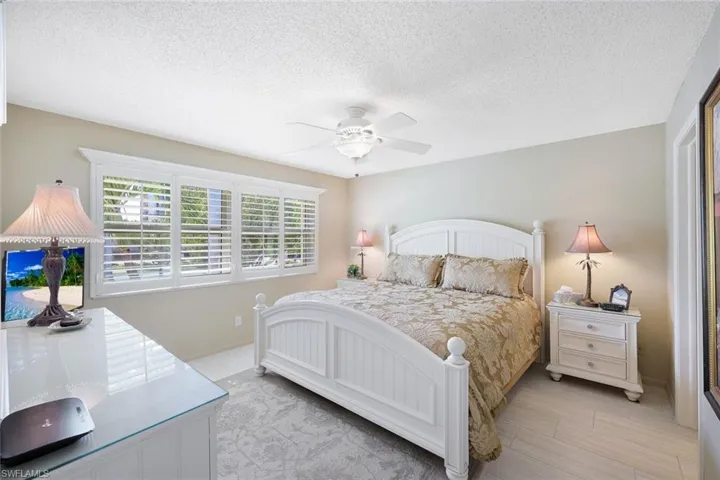 Bedroom featuring baseboards, a textured ceiling, and a ceiling fan