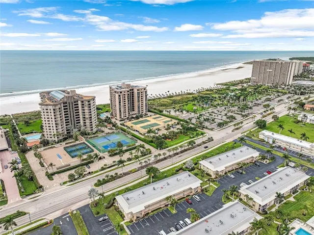 Drone / aerial view with a water view, a view of the beach, and a city view