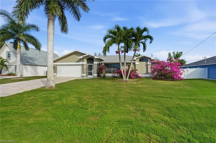 View of front of house with driveway, an attached garage, and stucco siding