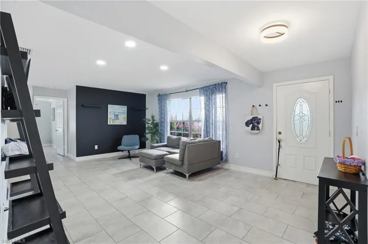 Entrance foyer featuring recessed lighting, beam ceiling, and light tile patterned floors