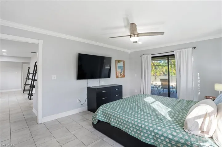 Bedroom featuring crown molding, access to exterior, a ceiling fan, and tile patterned floors