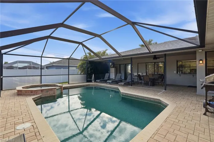 View of pool featuring a sunroom, a lanai, a patio, and a pool with connected hot tub