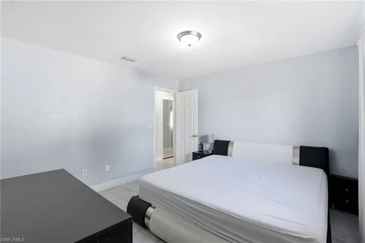 Bedroom with baseboards and light tile patterned floors