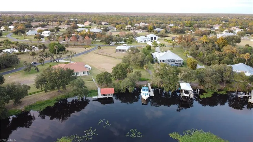 Aerial view of property and surrounding area with a nearby body of water and nearby suburban area