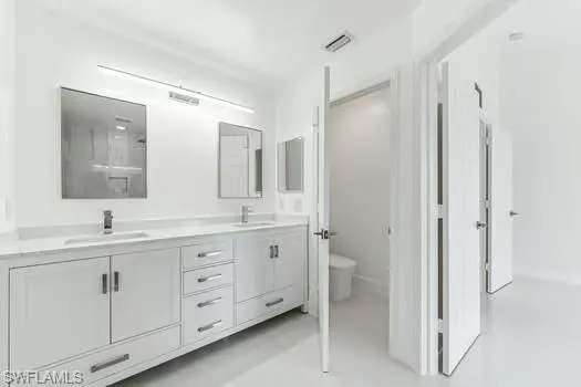 Bathroom featuring double vanity and toilet