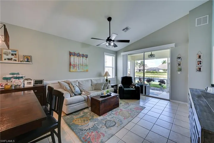 Vaulted ceiling, ceramic tile flooring, ceiling fan, and large sliding glass doors
