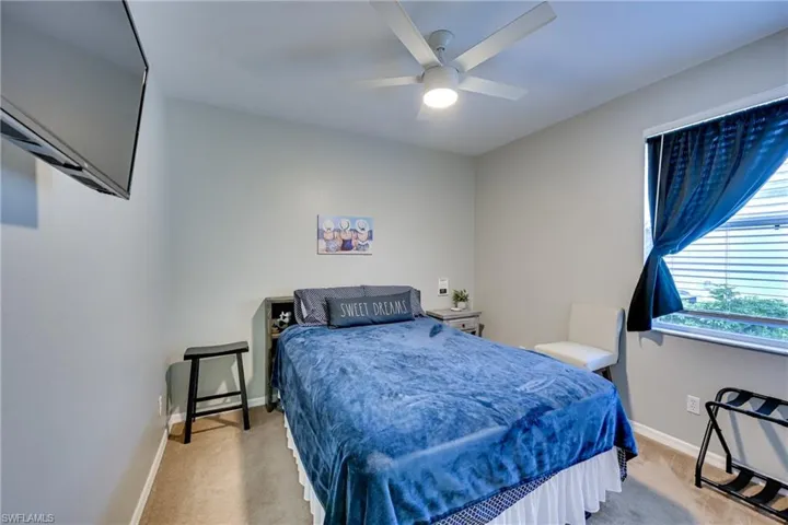 Guest Bedroom Neutral wall tones, carpeting, ceiling-mounted light fixture with fan, and window with horizontal blinds