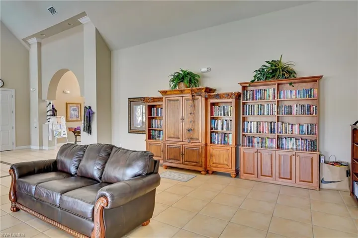 Vaulted ceilings, expansive tile flooring, and custom built-in wood cabinetry featuring extensive shelving and storage