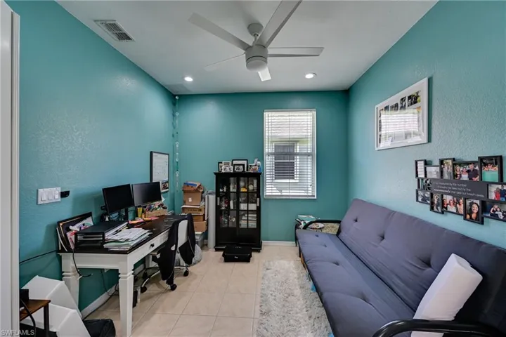 Neutral-toned tile flooring, recessed lighting, white ceiling fan with integrated light, and a single-pane window with white horizontal blinds