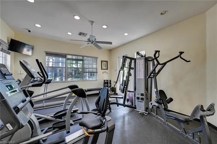 Fitness center featuring recessed lighting, a ceiling fan, multi-pane windows, and durable flooring