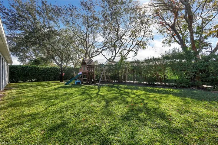 Fenced backyard with a playground