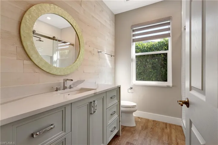 Bathroom with vanity, a stall shower, and light wood finished floors