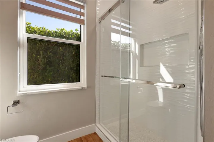 Full bath with a stall shower and baseboards
