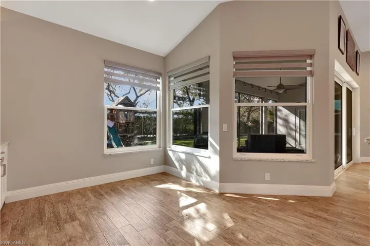 Unfurnished dining area featuring light wood-style flooring, healthy amount of natural light, vaulted ceiling, and ceiling fan