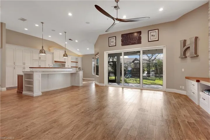 Unfurnished living room with ceiling fan, lofted ceiling, light wood-style flooring, and recessed lighting