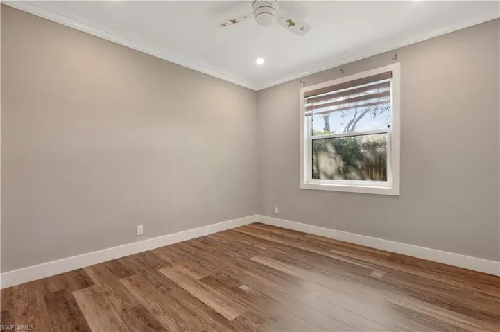 Spare room with wood finished floors, recessed lighting, a ceiling fan, and ornamental molding