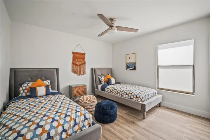 Bedroom featuring ceiling fan, baseboards, and wood finished floors