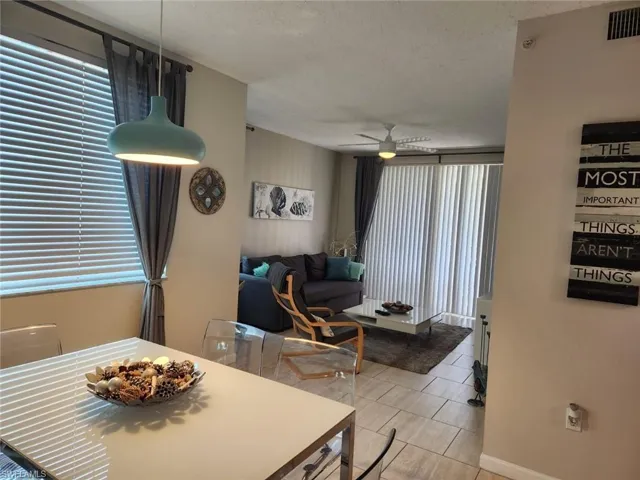 Dining space with a ceiling fan, a textured ceiling, plenty of natural light, and light tile patterned floors