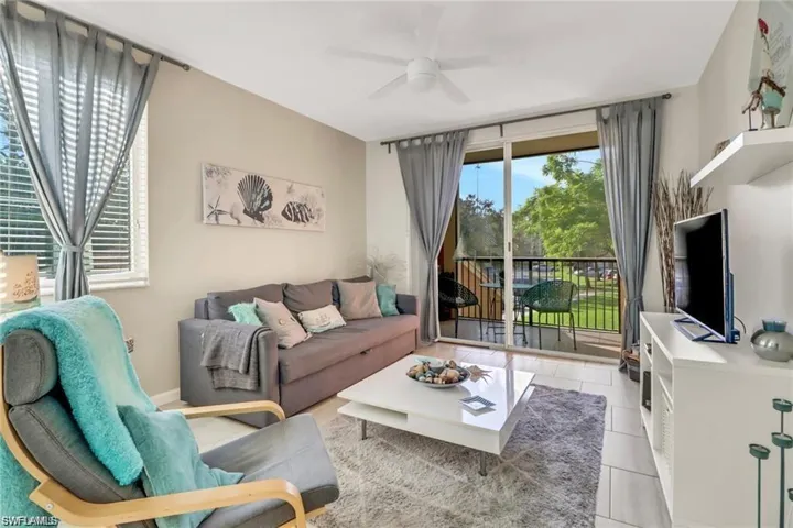 Living room featuring tile patterned floors and ceiling fan