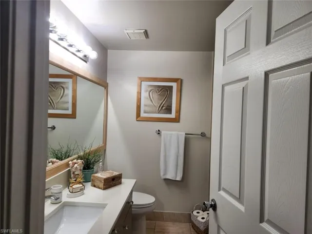 Half bathroom featuring vanity and toilet