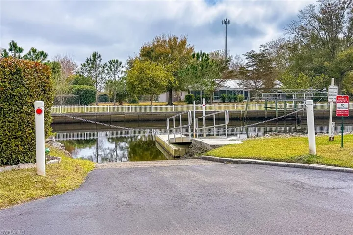 View of property's community with a dock, a boat ramp, and a water view