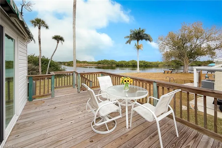 Wooden terrace with a water view and outdoor dining area