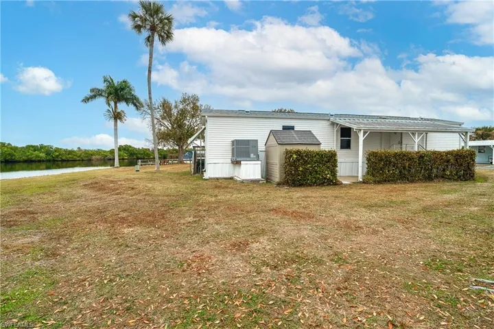 View of home's exterior with a yard and a water view