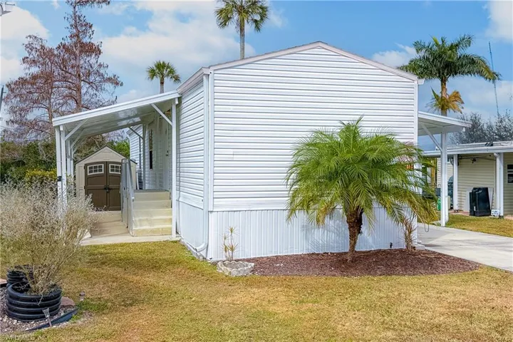 View of home's exterior featuring a storage unit and a yard
