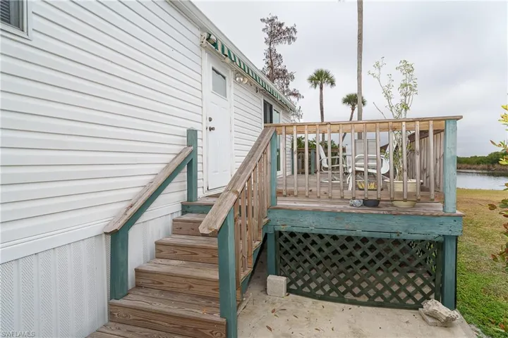 Wooden deck with a water view and stairway