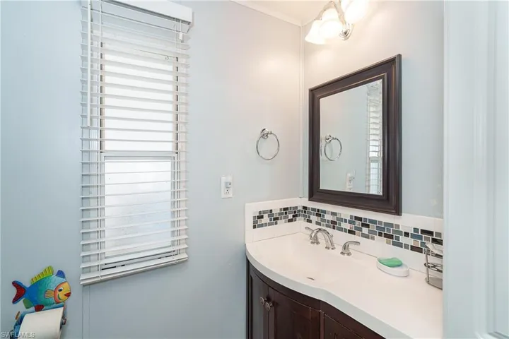 Bathroom featuring vanity, decorative backsplash, and plenty of natural light