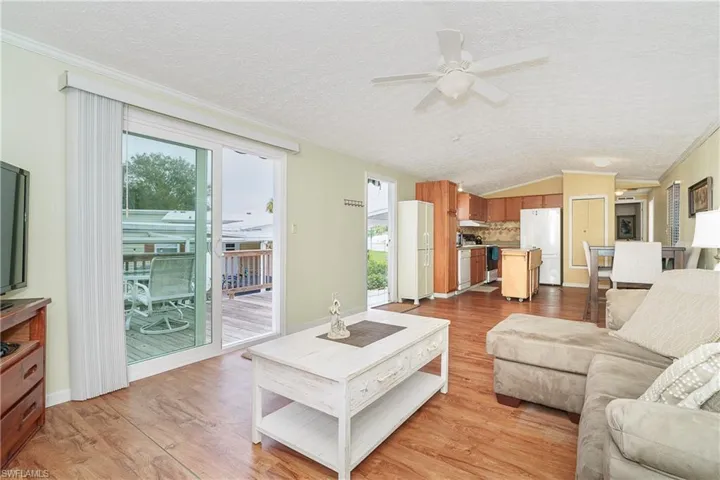 Living area featuring crown molding, ceiling fan, and light wood finished floors