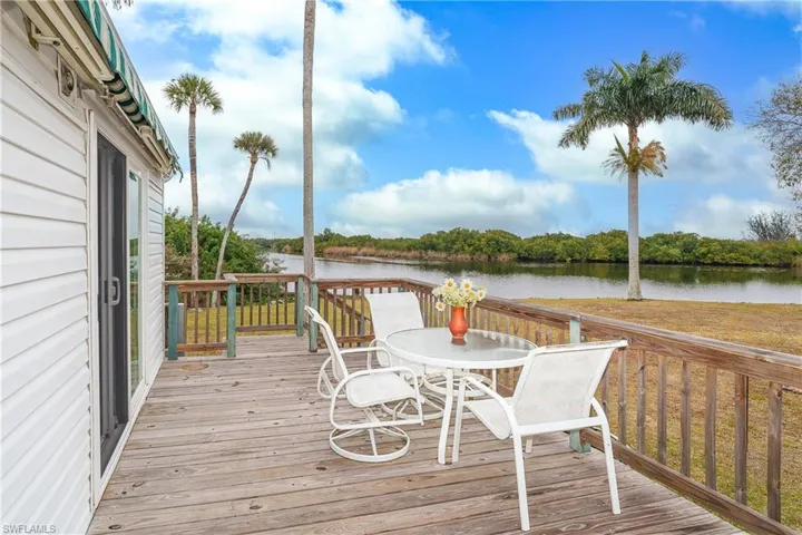 Deck with outdoor dining space and a water view