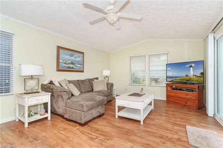Living area featuring ornamental molding, a ceiling fan, and light wood-style floors