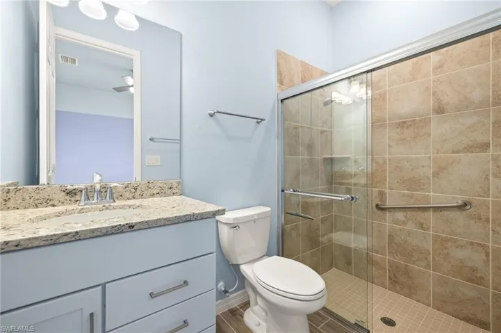 Full bathroom with vanity and a stall shower