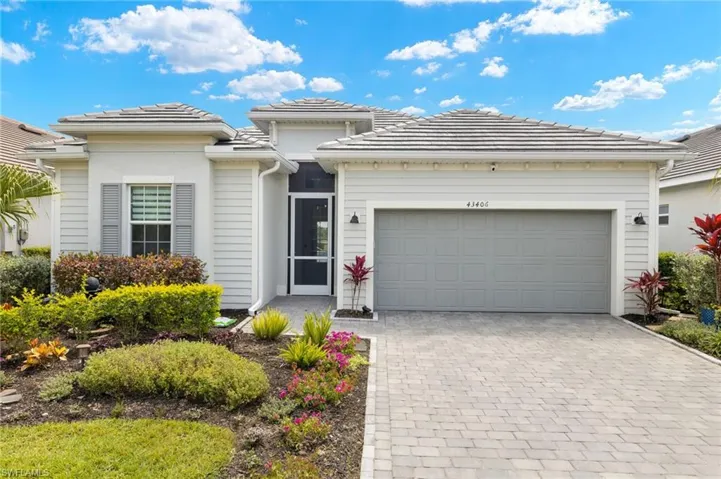 Prairie-style house featuring a tile roof, decorative driveway, and a garage