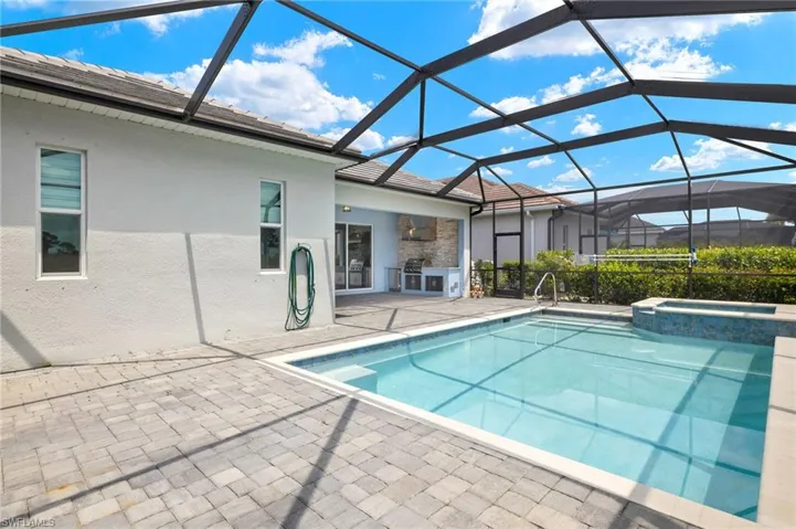 View of pool with exterior kitchen, a patio area, a lanai, and a pool with connected hot tub