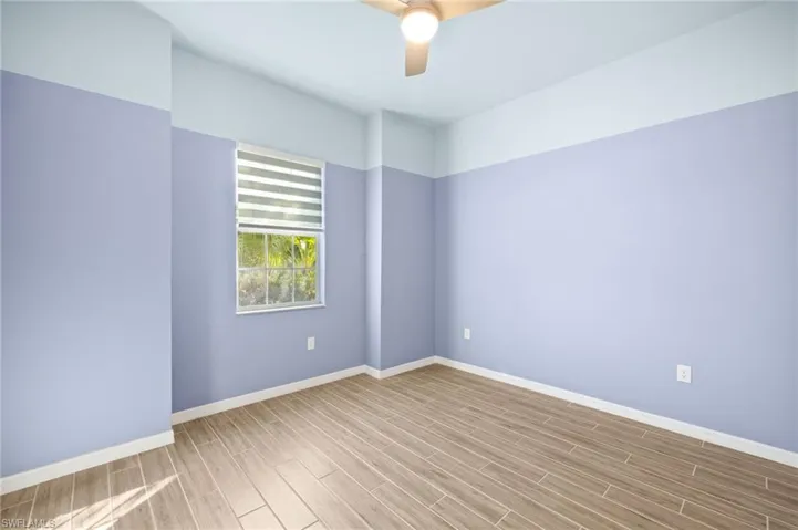 Empty room with wood finished floors and a ceiling fan