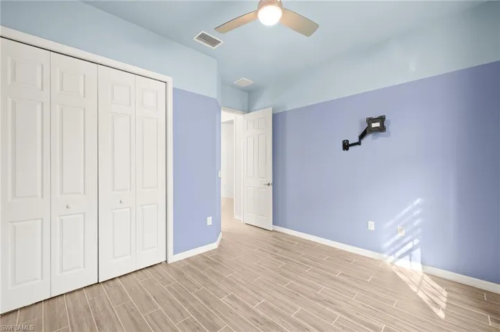 Unfurnished bedroom featuring a closet, light wood-style flooring, and ceiling fan
