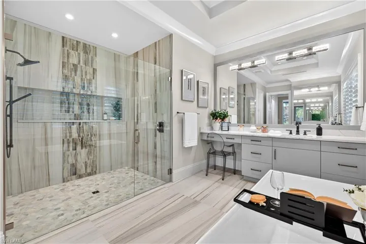 Bathroom with a shower stall, vanity, and ornamental molding